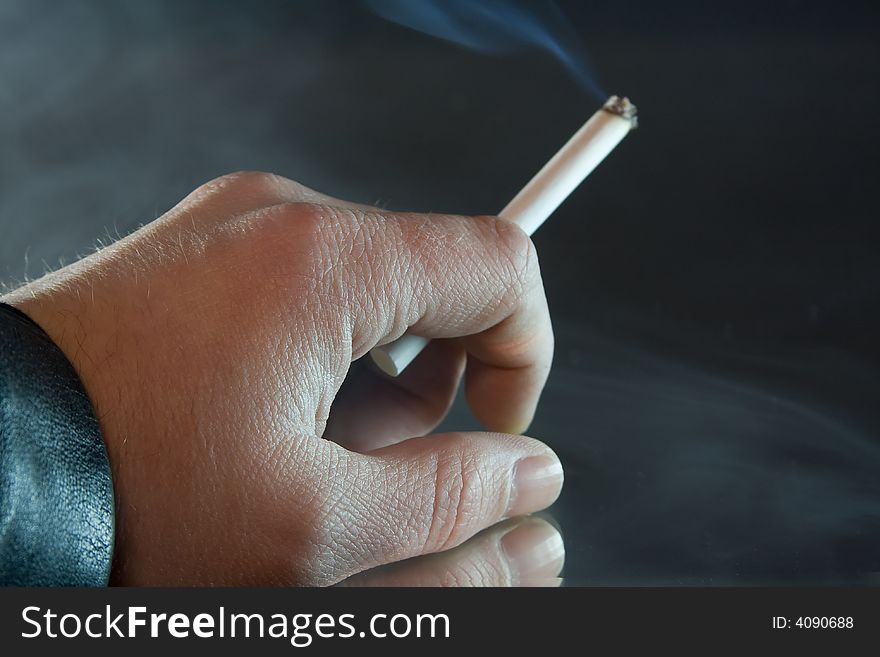 Human hand holding a cigarette. Human hand holding a cigarette