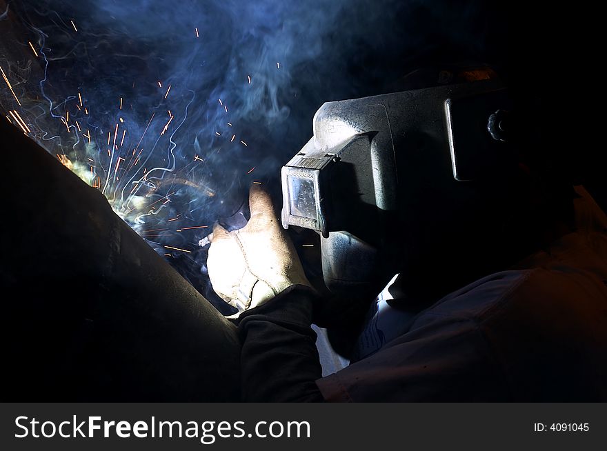 A welder working at shipyard at night. A welder working at shipyard at night