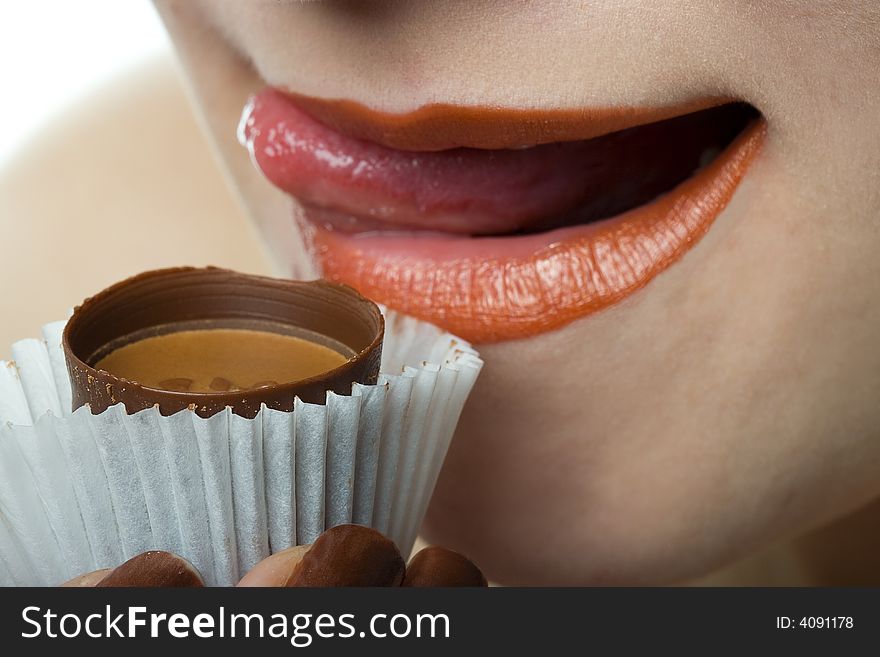 Woman lick lips with chocolate candy