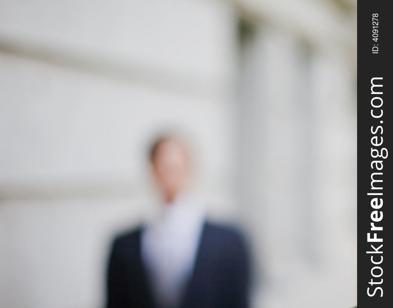 Waist-up front shot of businessman standing in front of building