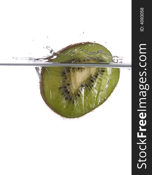 Slice of ripe kiwi falling in water on white background. Slice of ripe kiwi falling in water on white background