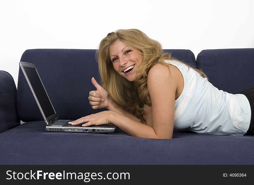 Woman lies on a sofa and works with a laptop. Woman lies on a sofa and works with a laptop.