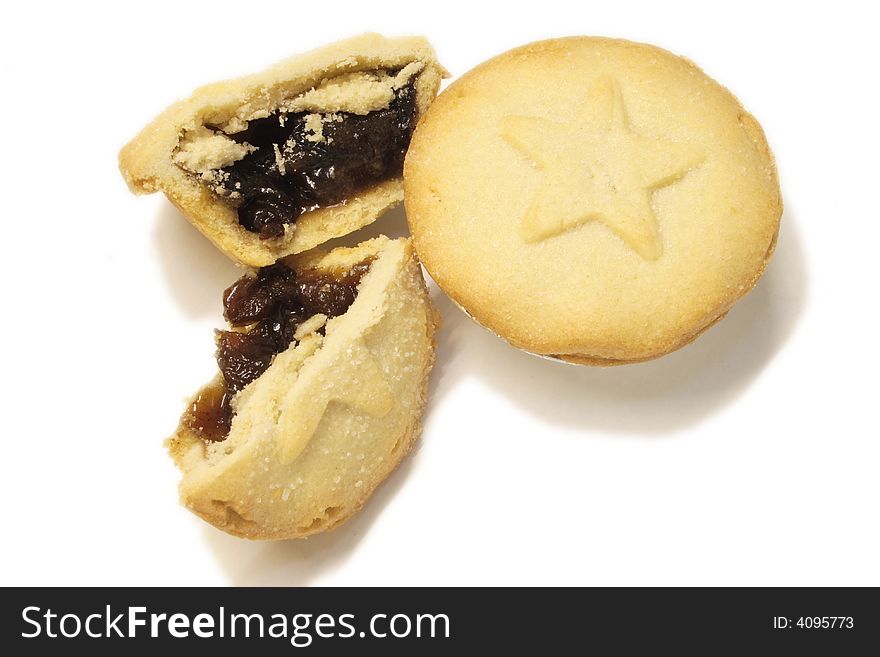 Two mincepies decorated with a star design one halved ready to eat isolated over a white background