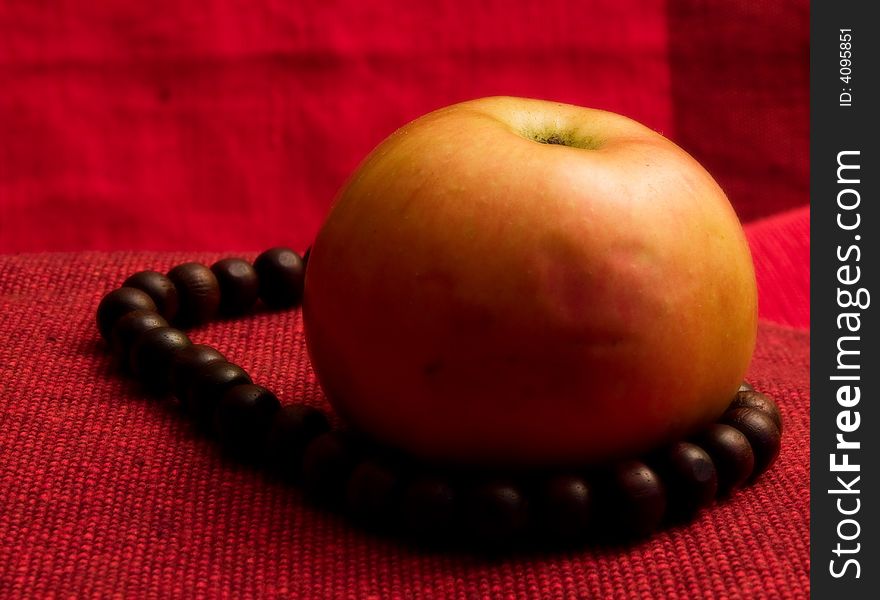 Single red apple background macro close up prayer beads. Single red apple background macro close up prayer beads