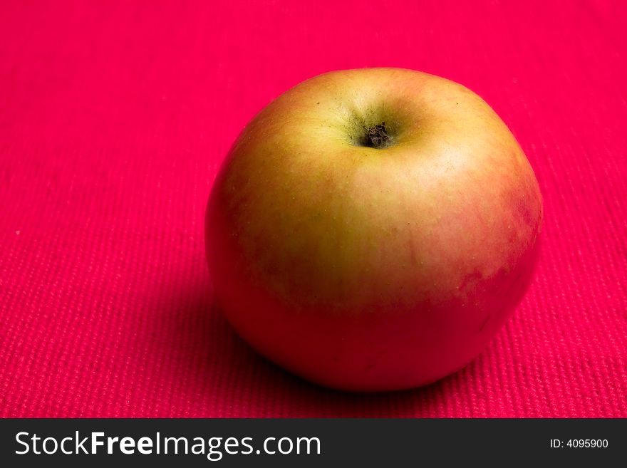 Single apple in red background close up macro studio. Single apple in red background close up macro studio