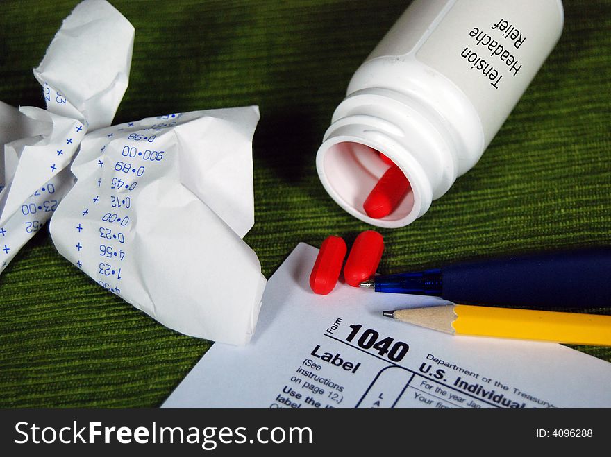 Bottle of aspirins and a 1040 tax form. Bottle of aspirins and a 1040 tax form.