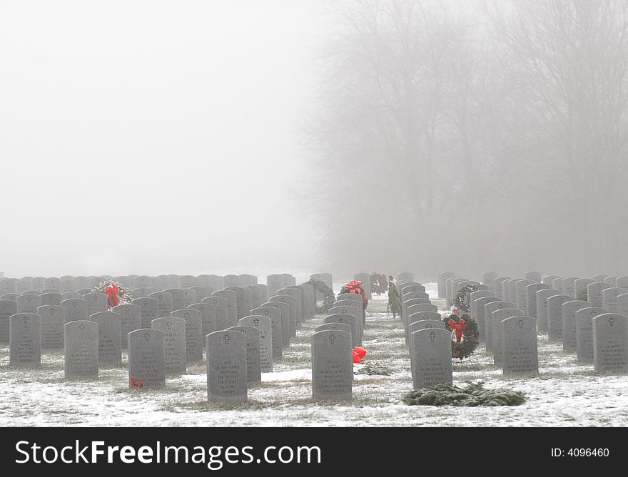 The headstones in a military cemetery on a foggy winter's morning. The headstones in a military cemetery on a foggy winter's morning