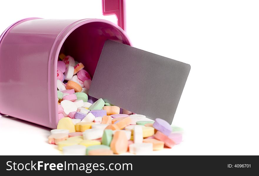 A pink mail box with conversation hearts and a blank notecard fallin out on a white background, Valentine's Day, with copy space. A pink mail box with conversation hearts and a blank notecard fallin out on a white background, Valentine's Day, with copy space