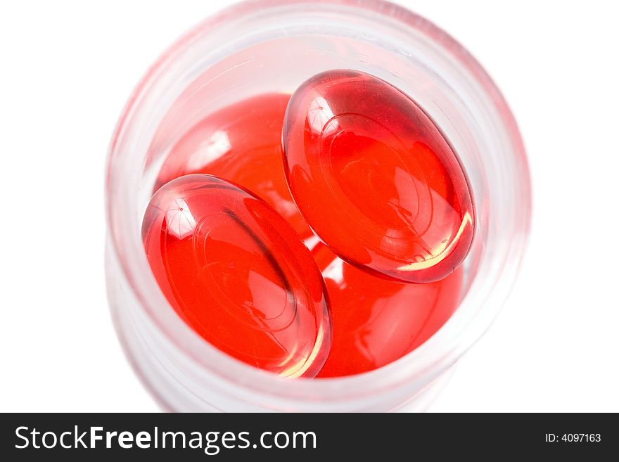 Red capsule pills in a bottle isolated. Red capsule pills in a bottle isolated
