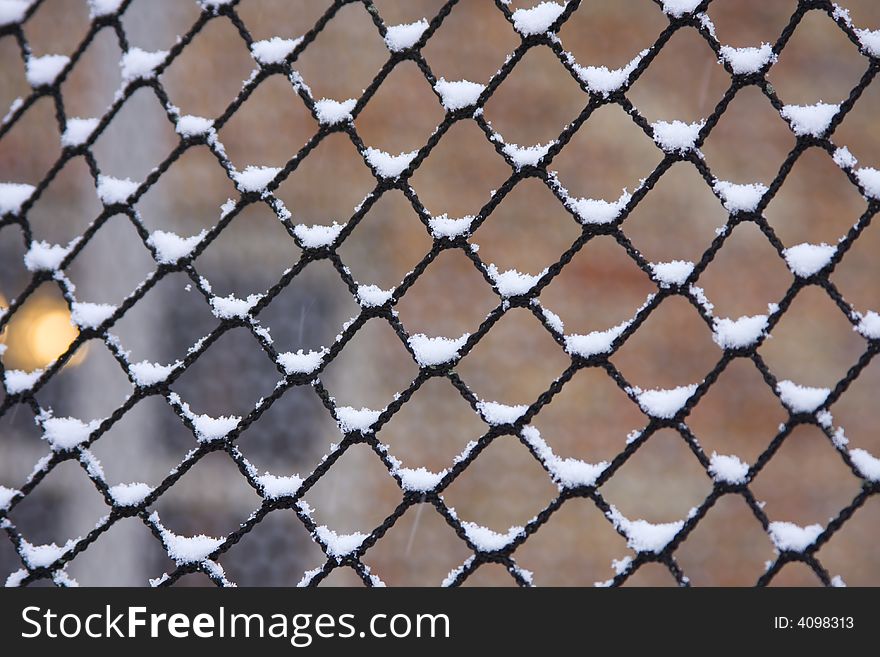 CLose-up of snow flakes on netting. CLose-up of snow flakes on netting