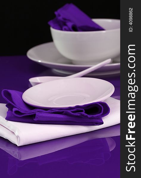 A table setting with modern dishes and napkins. A table setting with modern dishes and napkins