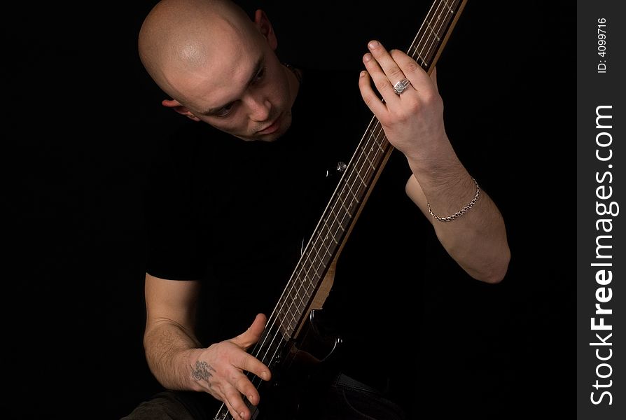 Portrait of the guitarist on a black background. Portrait of the guitarist on a black background