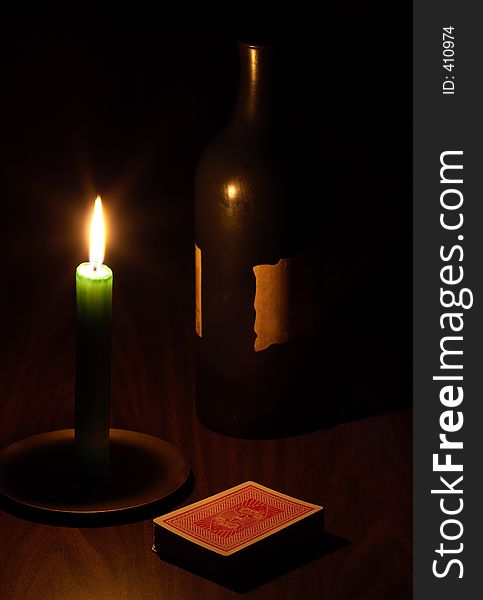 Wine, candle and playing cards at night