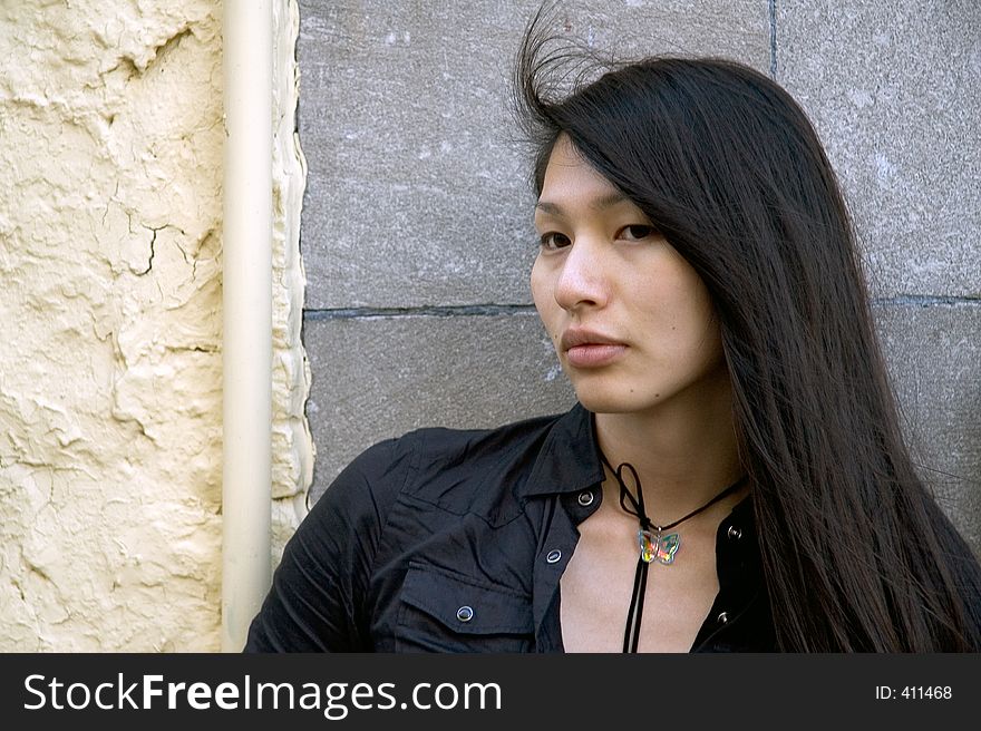 Girl standing by brick and yellow plaster wall. Girl standing by brick and yellow plaster wall