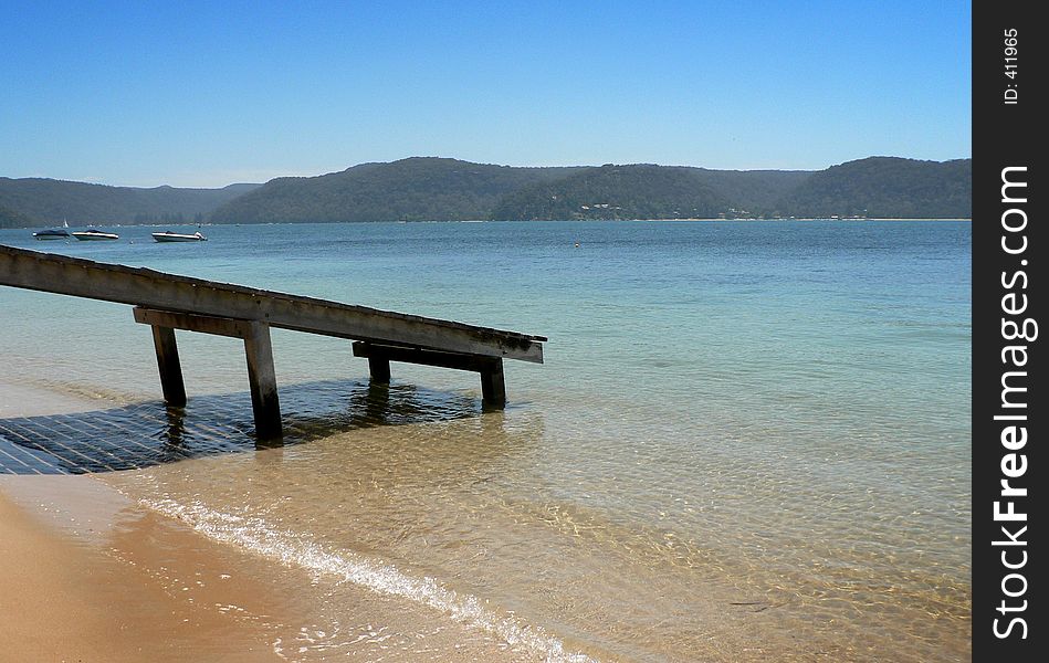 A jetty jutting out into the calm waters of a lake. A jetty jutting out into the calm waters of a lake