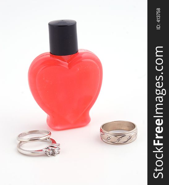A romantic oil bottle and wedding rings. A romantic oil bottle and wedding rings