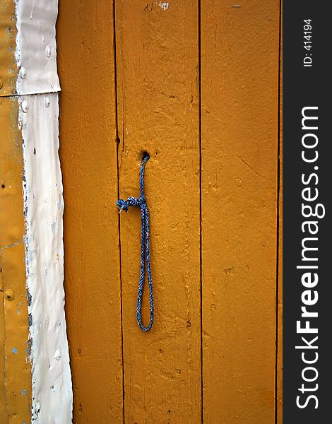 In Lofoten in northern Norway. A door on a fishing house, the oldest in Lofoten we was told. I couldn't help noticingthis strange door with the rope , blue, on the yellow door. In Lofoten in northern Norway. A door on a fishing house, the oldest in Lofoten we was told. I couldn't help noticingthis strange door with the rope , blue, on the yellow door.