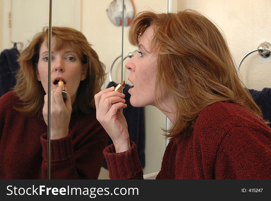 A woman applies makeup before going out for the night. A woman applies makeup before going out for the night.
