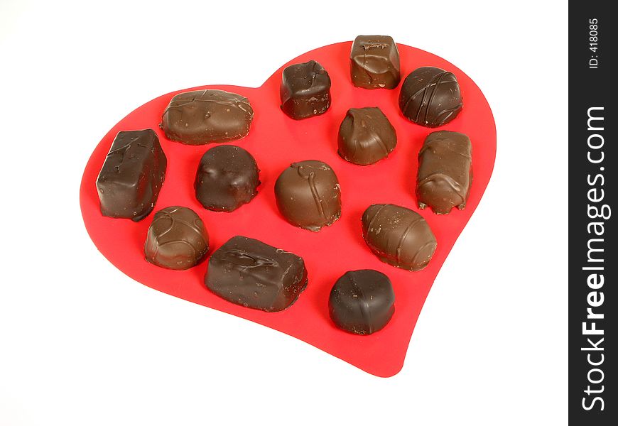 Large red heart with an assortment of chocolates over white. Large red heart with an assortment of chocolates over white