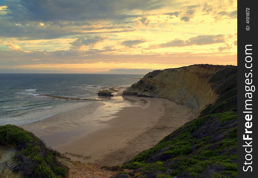 The Australian coastline stretching far with a sunset in the background. The Australian coastline stretching far with a sunset in the background.