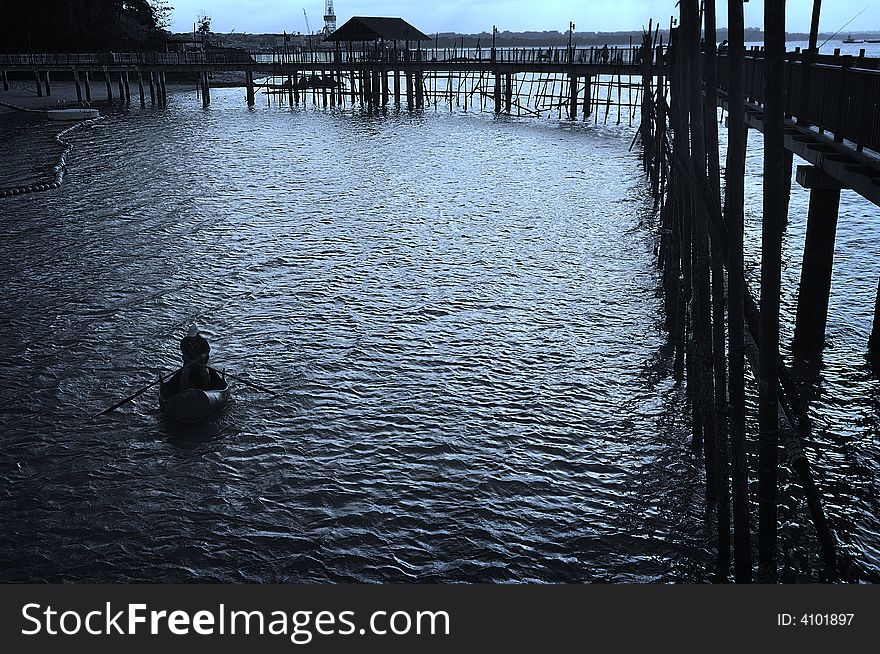 A fisherman rowing his boat after a hard day's work. A fisherman rowing his boat after a hard day's work