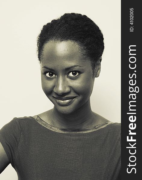 African American woman with a large sweet smile. This image is a yellow toned black and white image. African American woman with a large sweet smile. This image is a yellow toned black and white image.