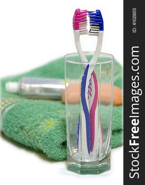 two toothbrushes in the glass container against the bright background.