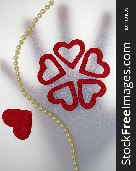 Valentine red hearts and pearls with background hand