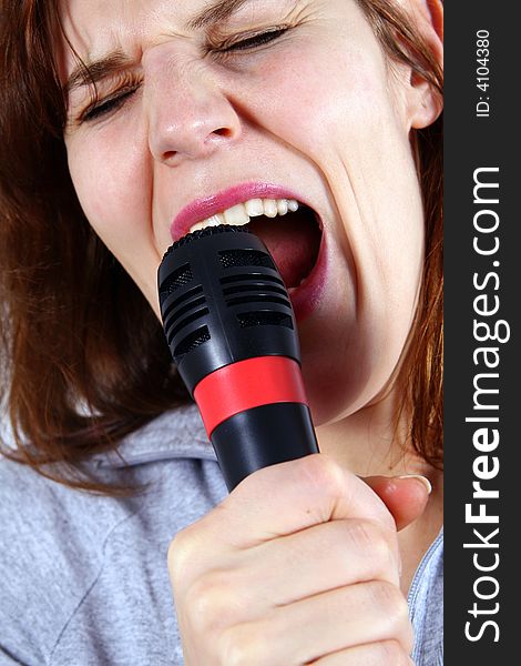 An isolated studio shot of young singer - using a microphone. An isolated studio shot of young singer - using a microphone.