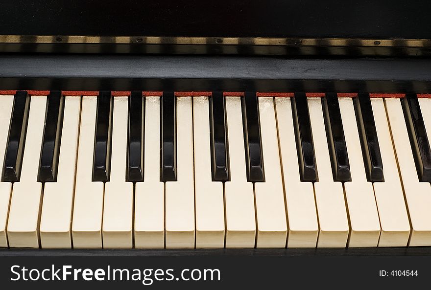 Antique piano with yellowish and dirty old keyboard