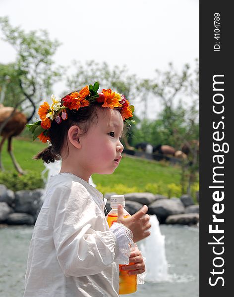 A beautiful Chinese young child with a coronet of flowers. A beautiful Chinese young child with a coronet of flowers