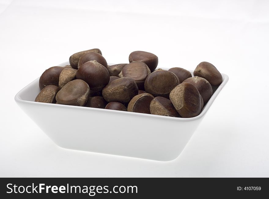 Chestnuts in the white bowl on the white backgrounds