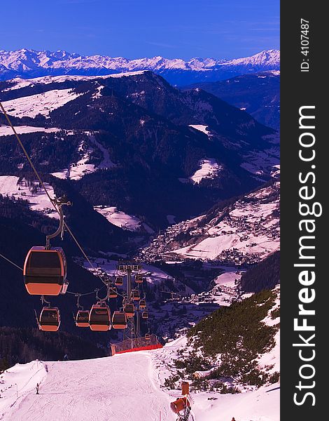 Skiers in a cable car ascending the mountain above the ski slope. Skiers in a cable car ascending the mountain above the ski slope