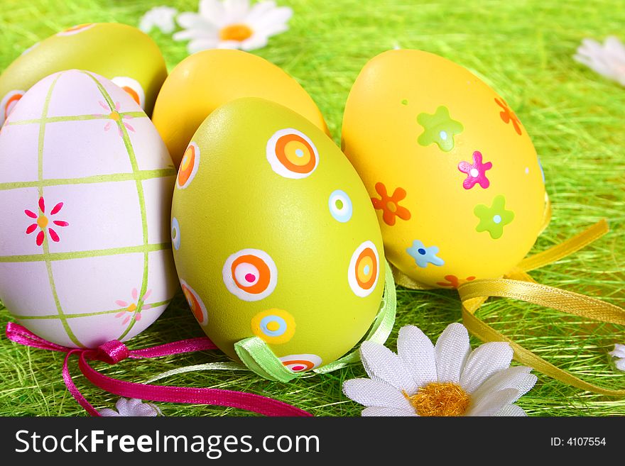 Pastel and colored Easter eggs on green