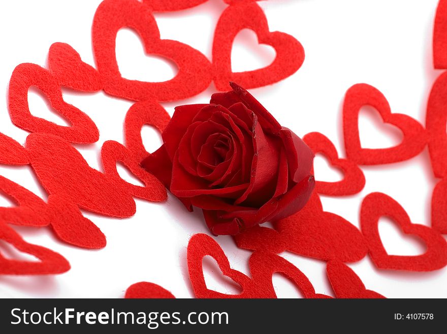 A rose and heart-shaped decorations on white. A rose and heart-shaped decorations on white