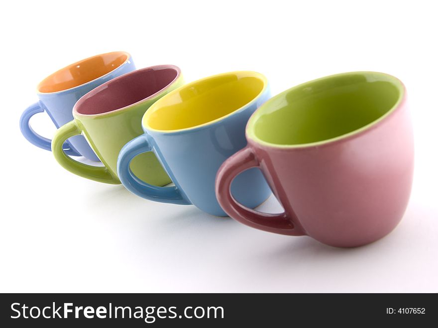 Four different colored cups aligned on white background