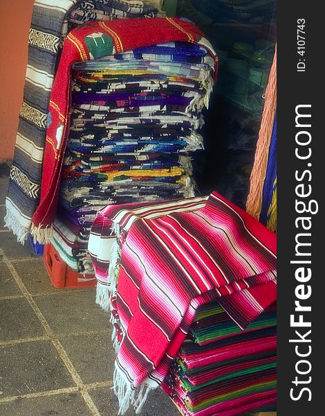 Stacks of colorful mexican blankets at a flea market. Stacks of colorful mexican blankets at a flea market