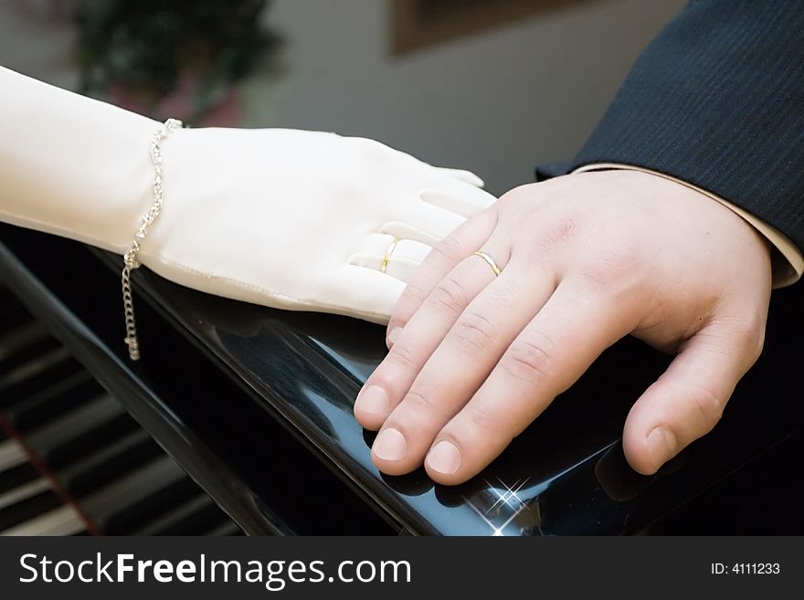 Hands of a newly-married couple with wedding rings