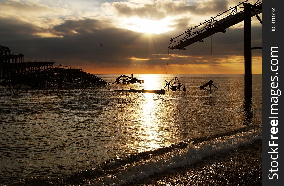 View of the burnt down West Pier in Brighton, England, during sunset. View of the burnt down West Pier in Brighton, England, during sunset.