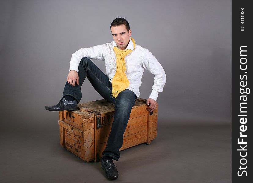 Modern young guy sitting on the wooden box