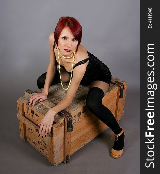 Sexy girl sitting on the wooden box