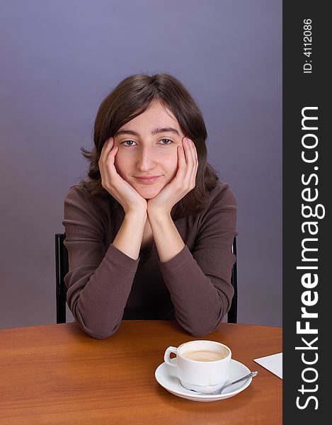 The beautiful girl with a coffee mug on a grey background. The beautiful girl with a coffee mug on a grey background