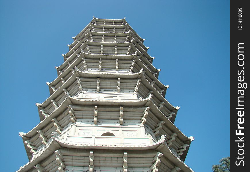 A white tower in the blue sky. A white tower in the blue sky