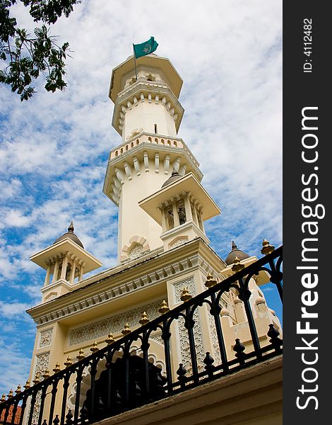 Impressive mosque tower architecture with blue sky white clouds. Impressive mosque tower architecture with blue sky white clouds