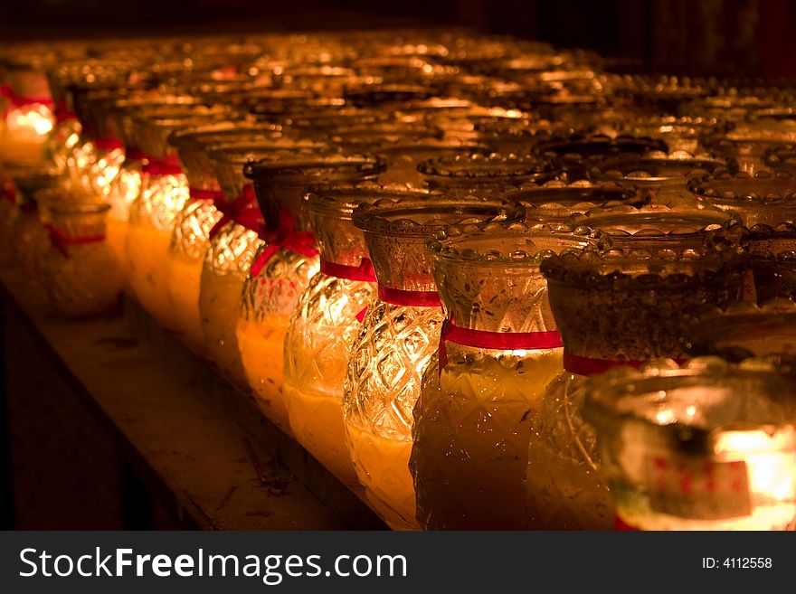 Rows of candles in glass lighted
