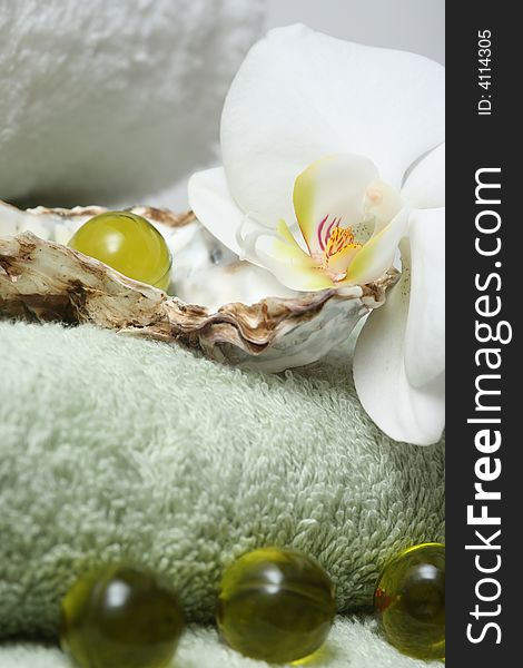 Bath oil pearls with orchid and green towels. Bath oil pearls with orchid and green towels.