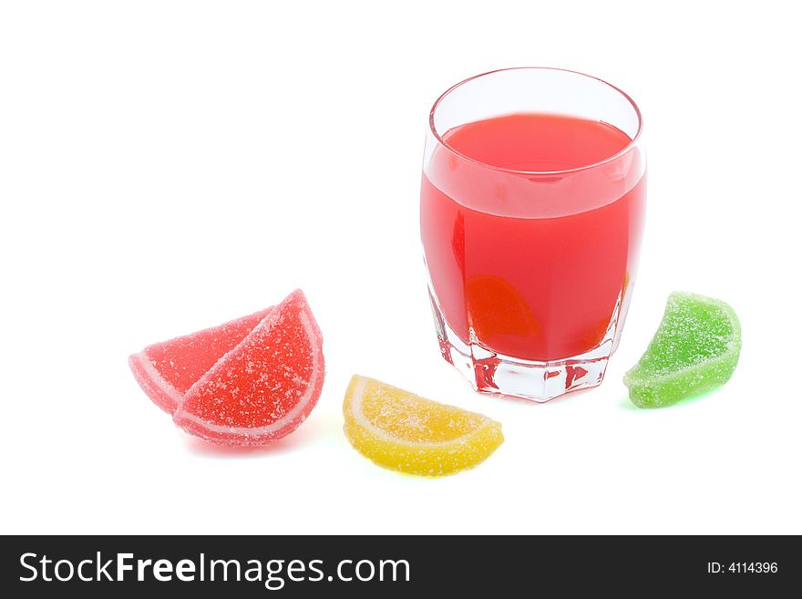 Glass of red juice and fruit jellies