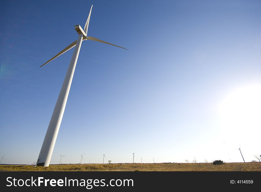 Energy producing wind turbines against a blue sky with copy space