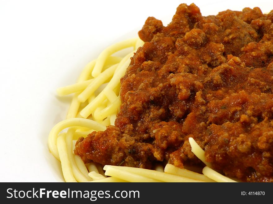 Fresh cooked white spaghetti pasta and juicy tomato meat sauce, often referred to as Italian Spaghetti, on white porcelain plate and white background. Close up macro. Fresh cooked white spaghetti pasta and juicy tomato meat sauce, often referred to as Italian Spaghetti, on white porcelain plate and white background. Close up macro.