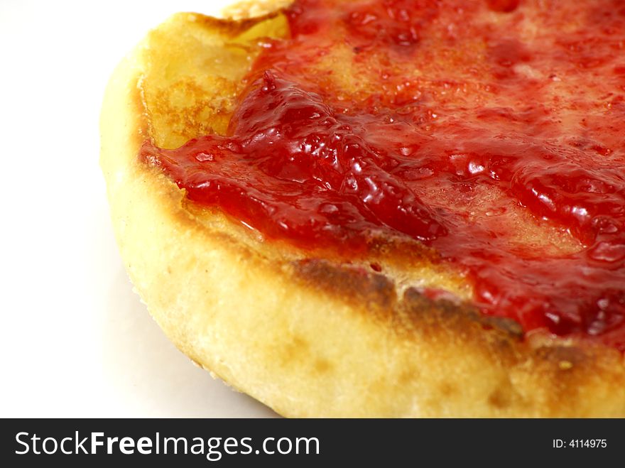 Lightly toasted sourdough english muffins with butter and strawberry preserves on white background.